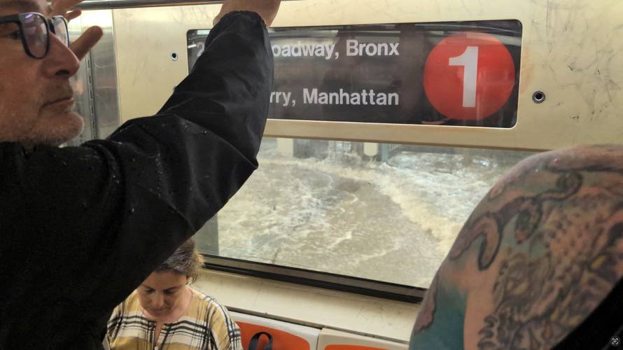 A man looks on from a subway as a station is flooded in New York