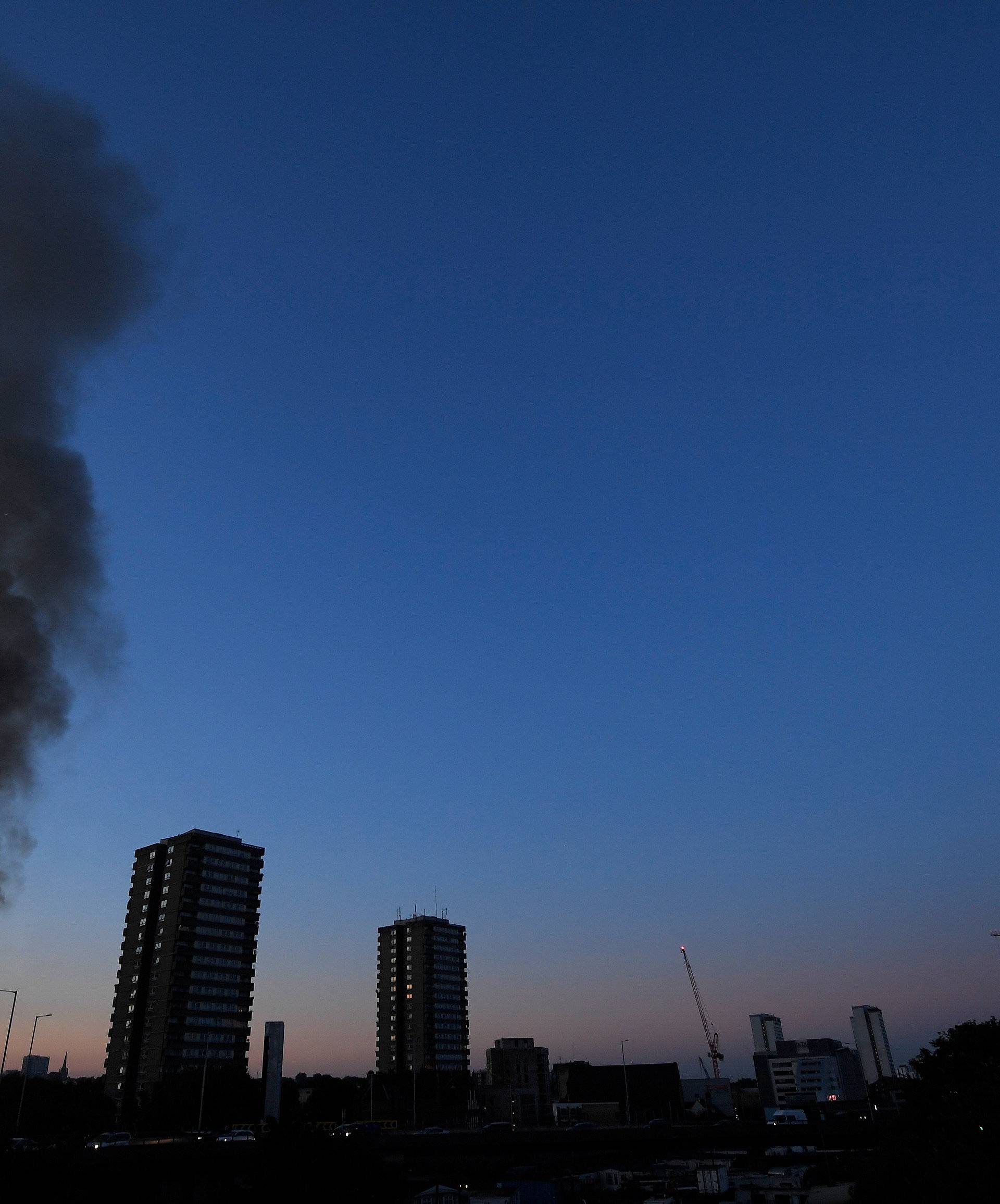 Flames and smoke billow as firefighters deal with a serious fire in a tower block at Latimer Road in West London