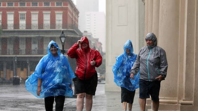 Tourists walk through rain in the French Quarter caused by Hurricane Barry in New Orleans
