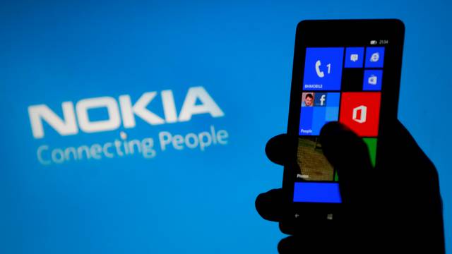 A woman poses with a Nokia Lumia smartphone in this photo illustration