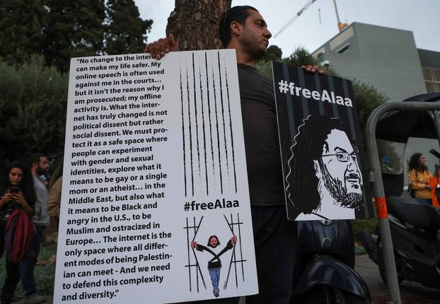 A demonstrator holds placards as he demands the release of Egyptian-British hunger striker Alaa Abd el-Fattah near the British Embassy in Beirut