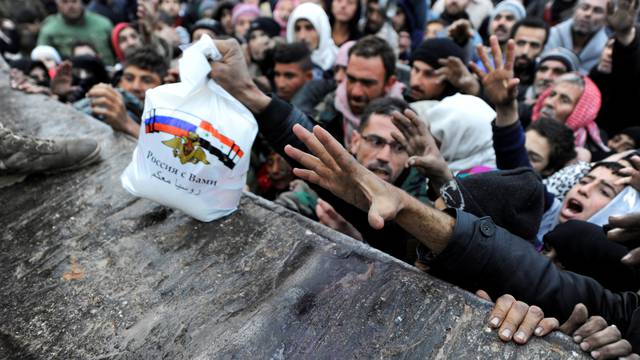 Syrians who have been evacuated from eastern Aleppo, reach out for Russian food aid in government-controlled Jibreen area in Aleppo
