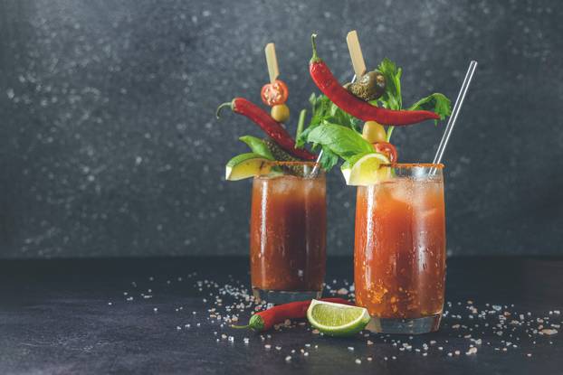 Two glasses of tomato juice with vodka, celery, spices, salt and