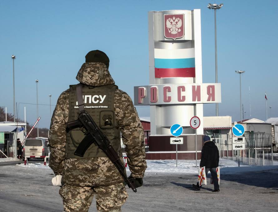 A member of the Ukrainian State Border Guard Service stands guard at a crossing point on the border between Russia and Ukraine in Kharkiv Region