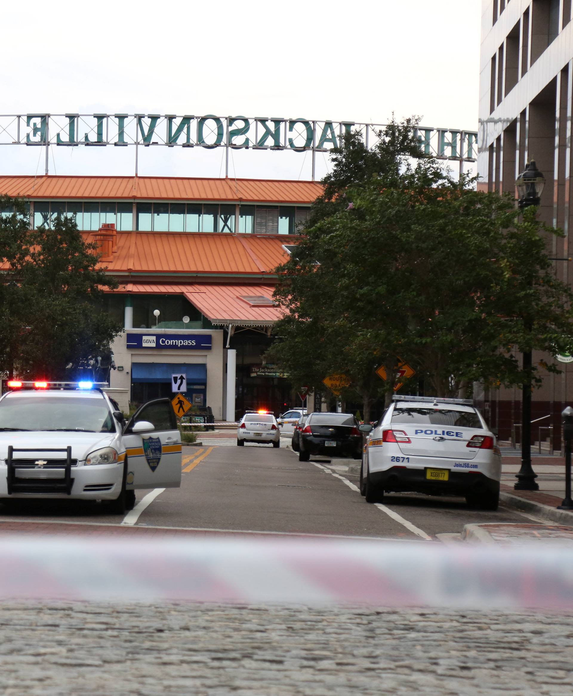 Police officers cordon off a street outside The Jacksonville Landing after a shooting during a video game tournament in Jacksonville