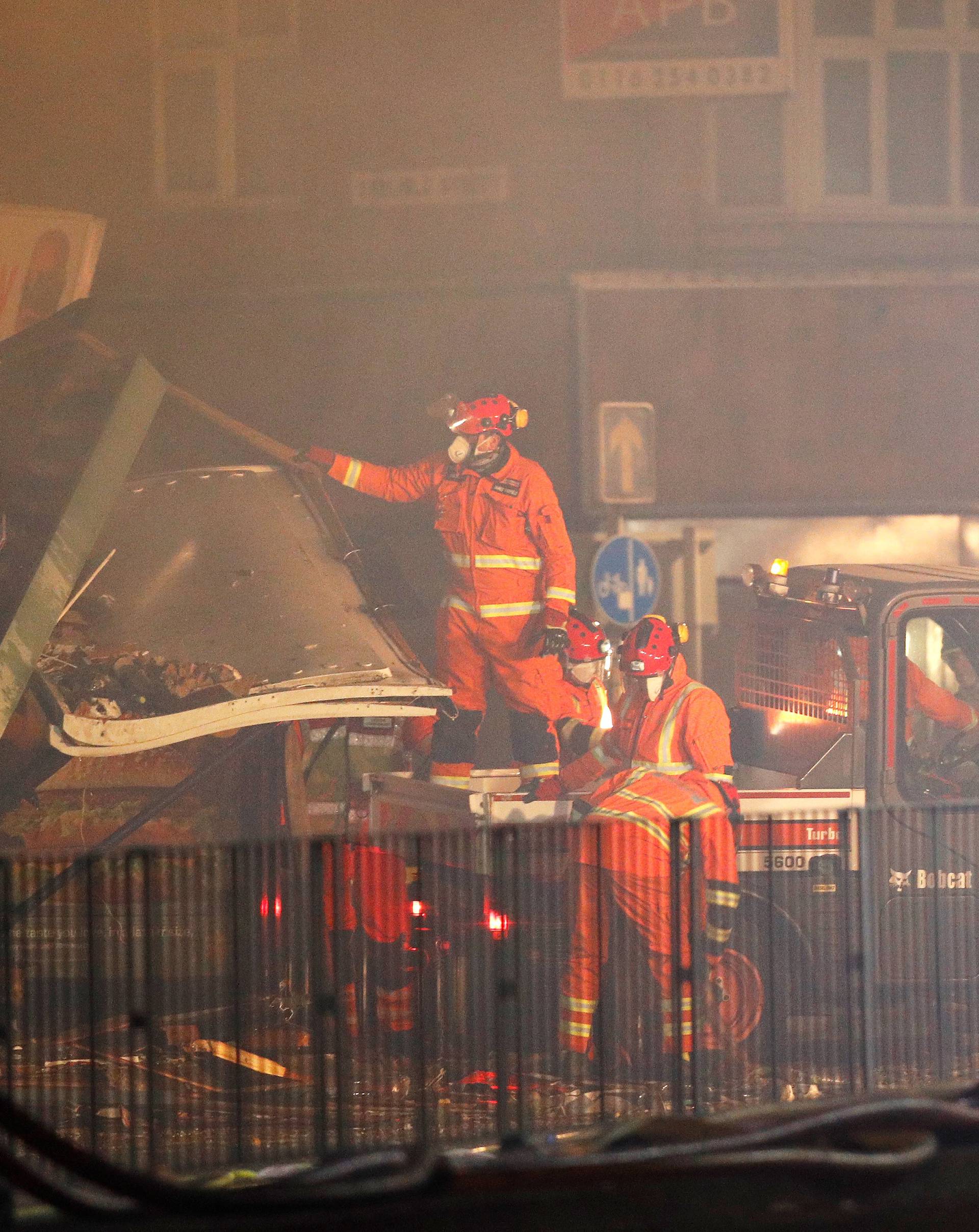 Members of the emergency services work at the site of an explosion which destroyed a convenience store and a home in Leicester