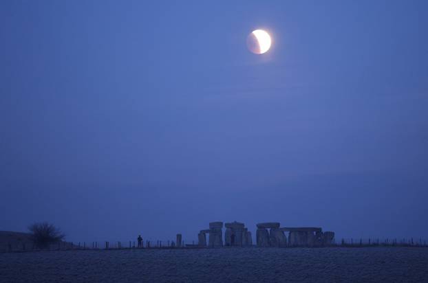 Lunar eclipse seen ahead of totality at Stonehenge stone circle, near Amesbury