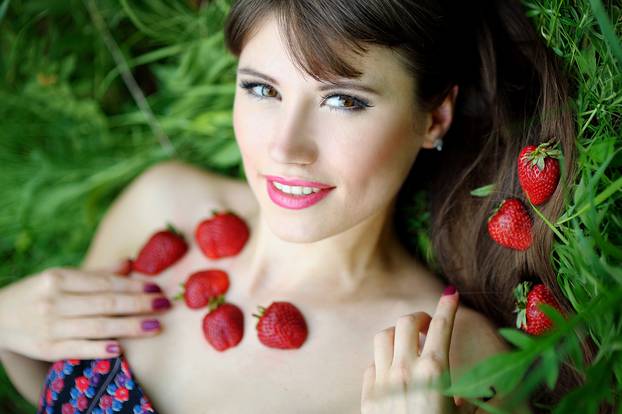 Beautiful brunette girl with strawberry