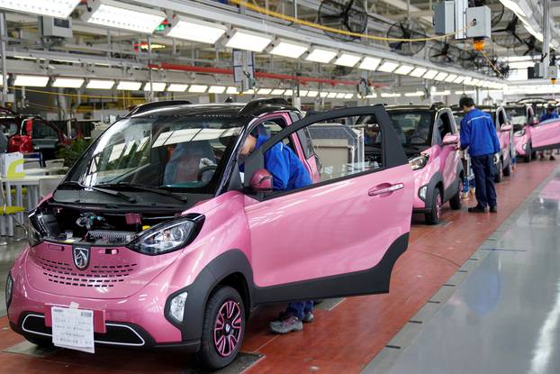 FILE PHOTO: Workers inspect Baojun E100 all-electric battery cars at a final assembly plant operated by General Motors Co and its local joint-venture partners in Liuzhou