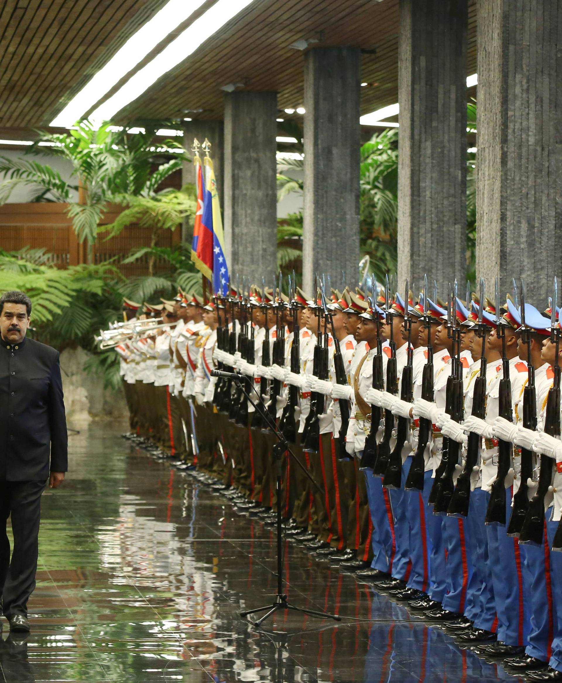 Cuban President Miguel Diaz-Canel and Venezuela's President Nicolas Maduro review an honour guard during a ceremony at the Revolution Palace in Havana