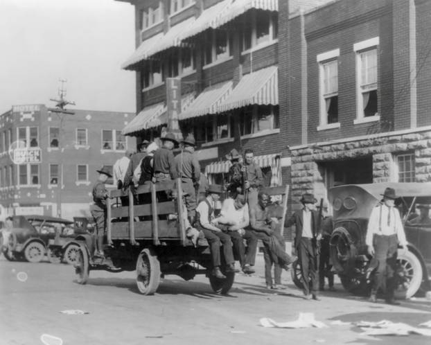 A truck carries soldiers and African Americans near the Litan Hotel during 1921 race massacre in Tulsa