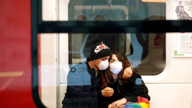 Couple wearing face masks is seen in the subway in Duomo underground station in Milan