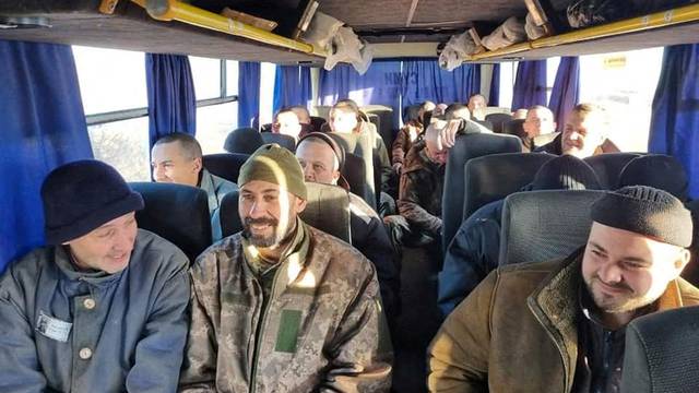 Ukrainian prisoners of war sit inside a bus after a swap in an unknown location in Ukraine