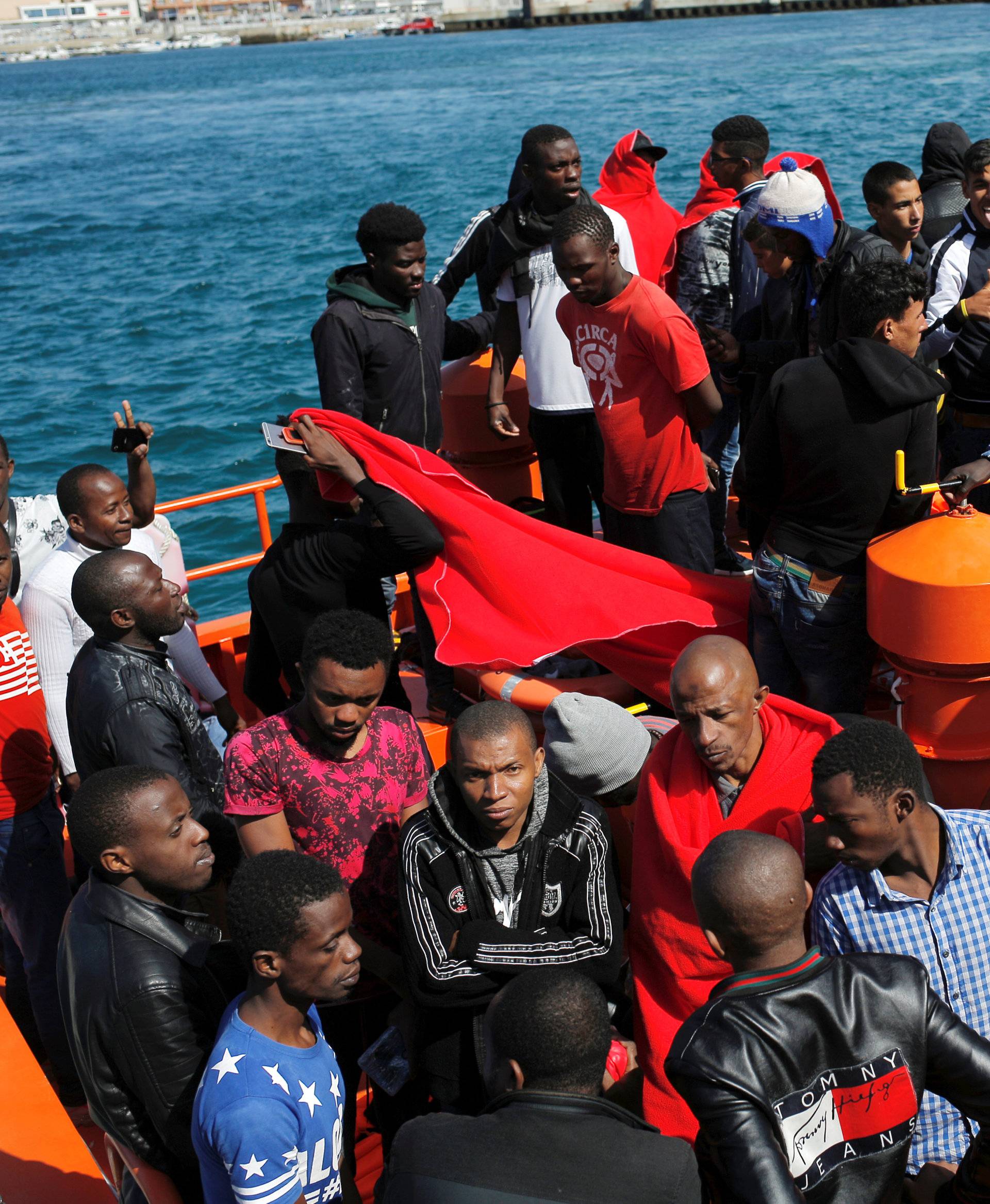 Migrants, intercepted aboard two dinghies off the coast in the Strait of Gibraltar, wait on a rescue boat to disembark after arriving at the port of Tarifa