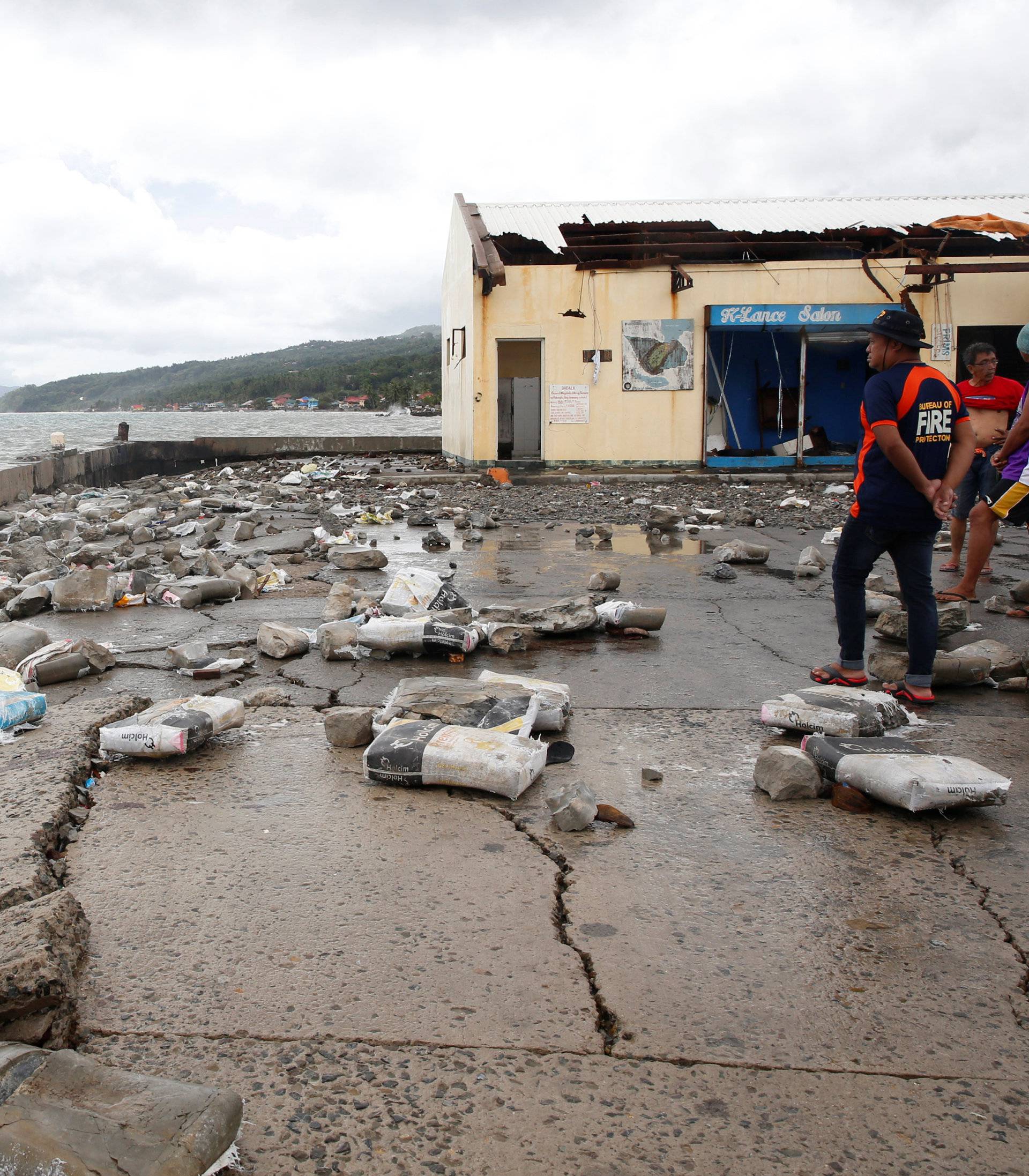 Residents gather in a partially damaged port in Mabini, Batangas, after it was hit by Typhoon Nock-Ten