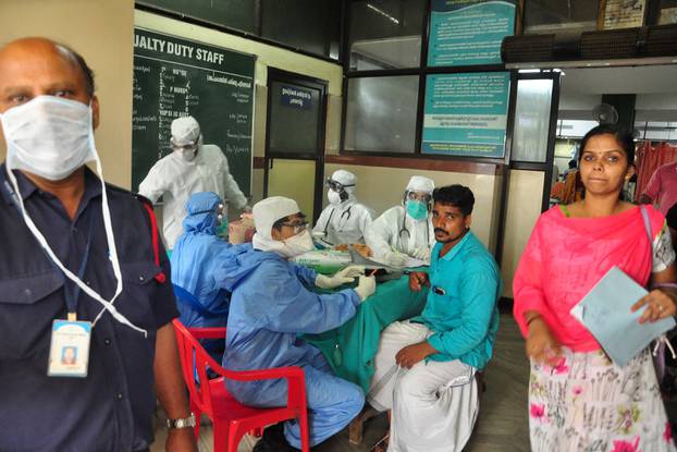 Medics wearing protective gear examine a patient at a hospital in Kozhikode in the southern state of Kerala