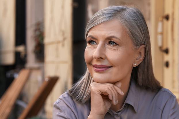 Portrait of beautiful smiling senior woman outdoors, space for t