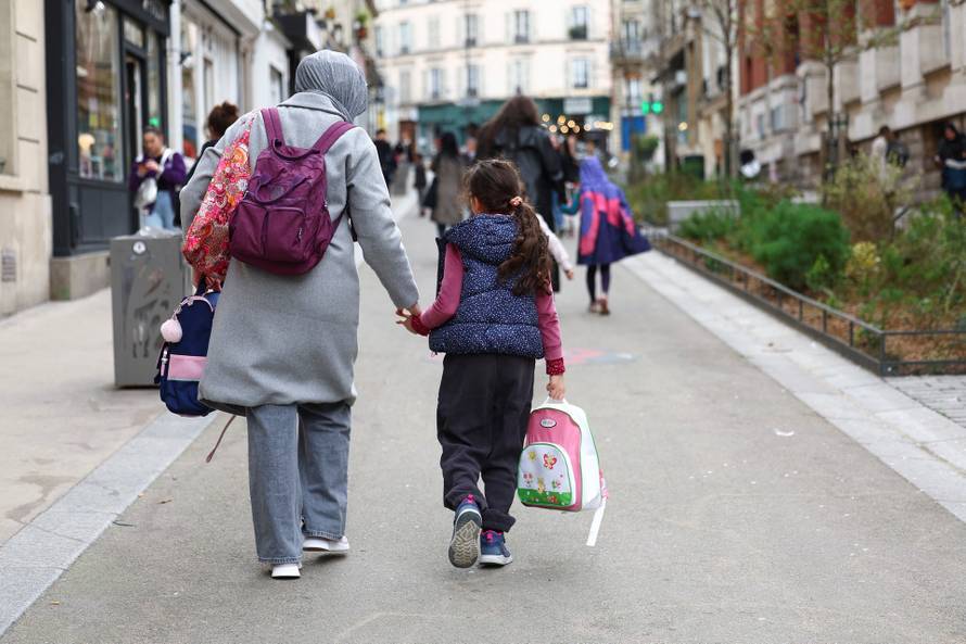 People walk on street Rue Hermel, in Paris