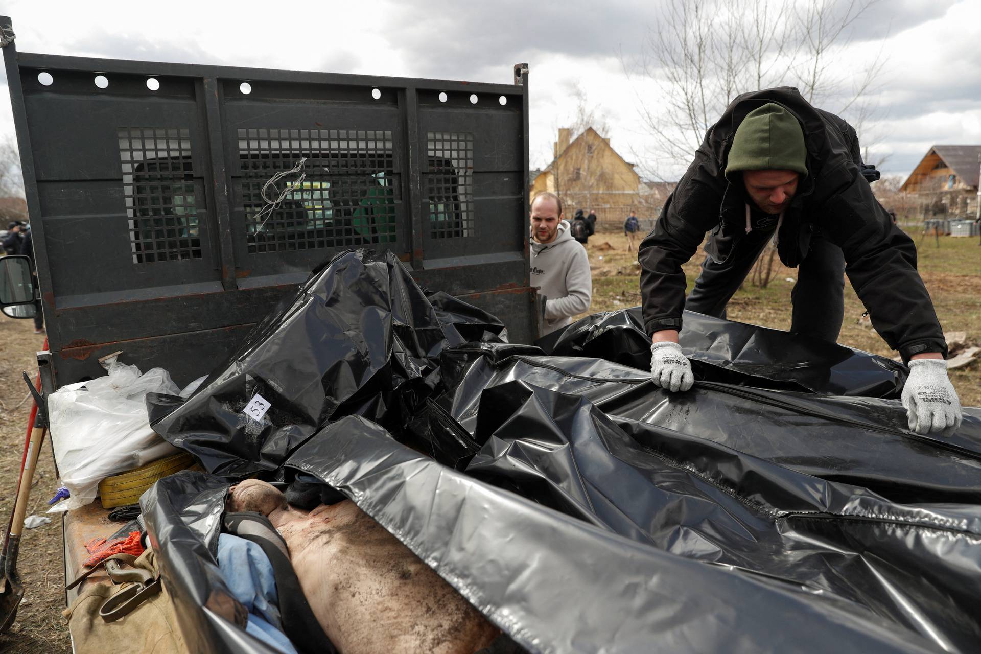 A worker prepares for transportation the bodies of civilians exhumed from a mass grave in the town of Bucha