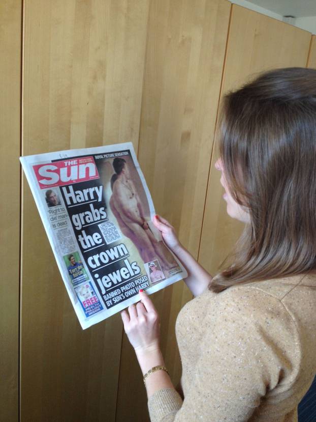 Woman looks at the Sun Newspaper, London, Britain - 23 Aug 2012