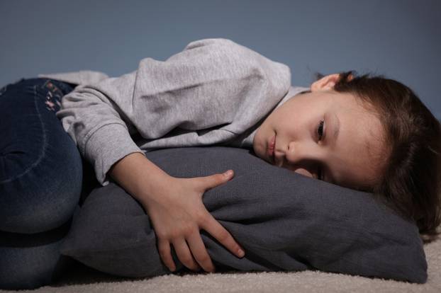 Lonely sad girl at home. saddened alarmed child alone at home.