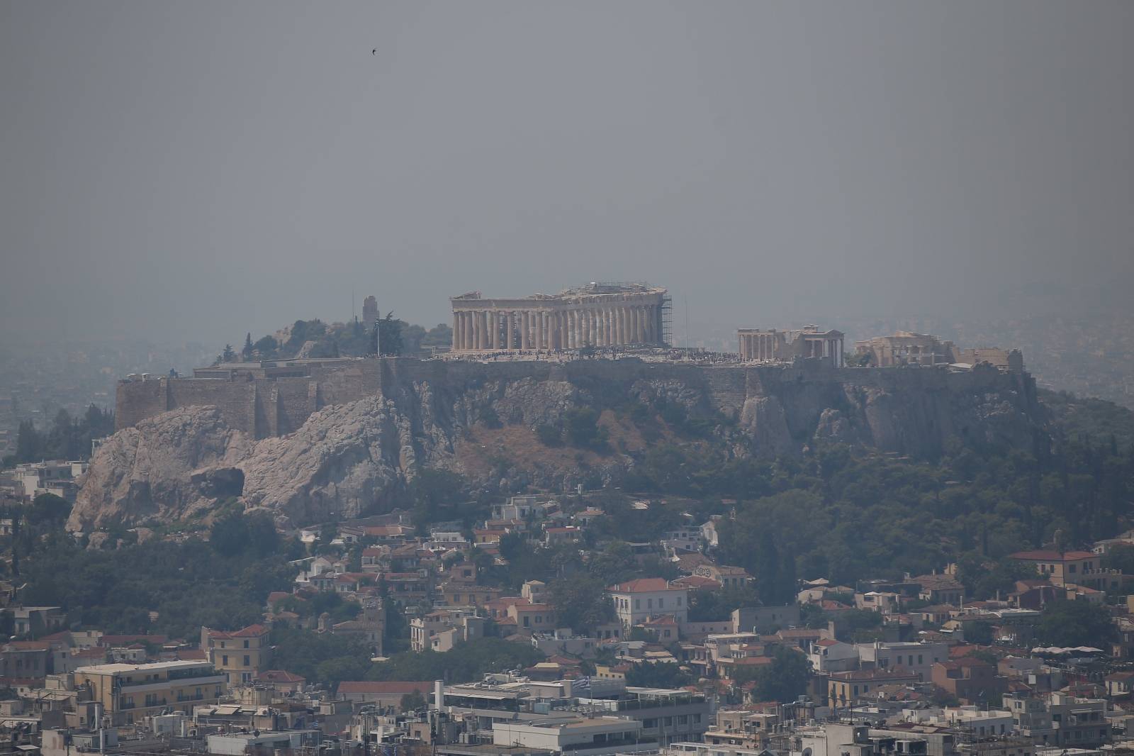 Acropolis hill with the Parthenon temple is covered with smoke from a wildfire burning the Island of Evia. in Athens