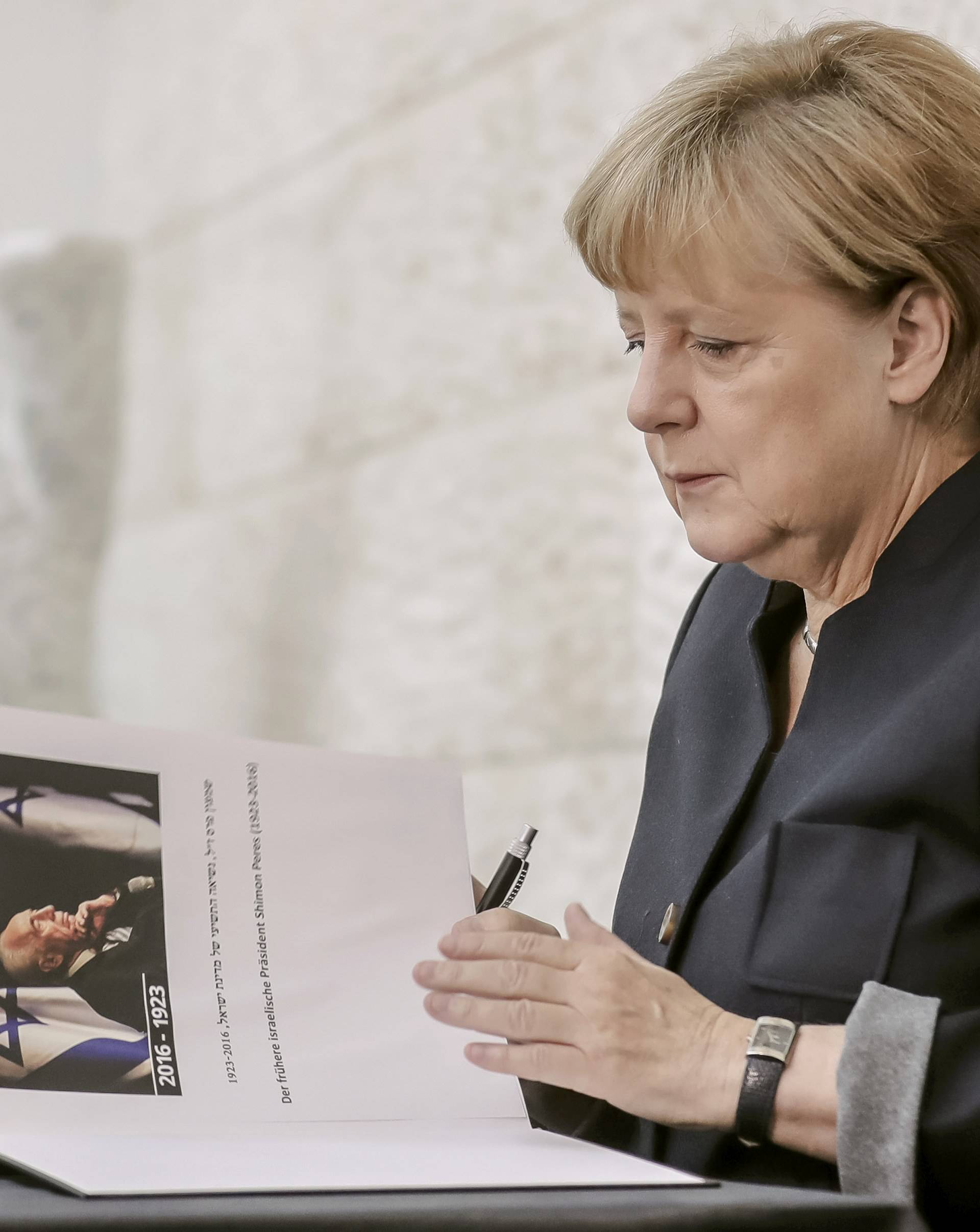 German Chancellor Merkel sings a book of condolence for former Israeli President Peres in Berlin