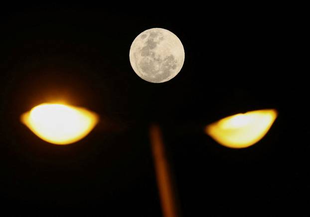 A view shows a full moon known as the 'Blue Moon' over a lamp post in Cape Town