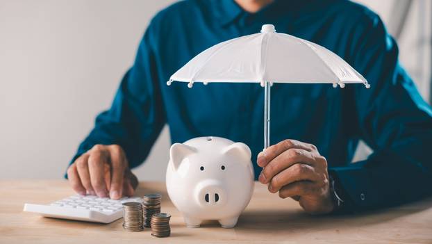 Man,Holds,White,Umbrella,Over,Piggy,Bank,To,Protect,Money,