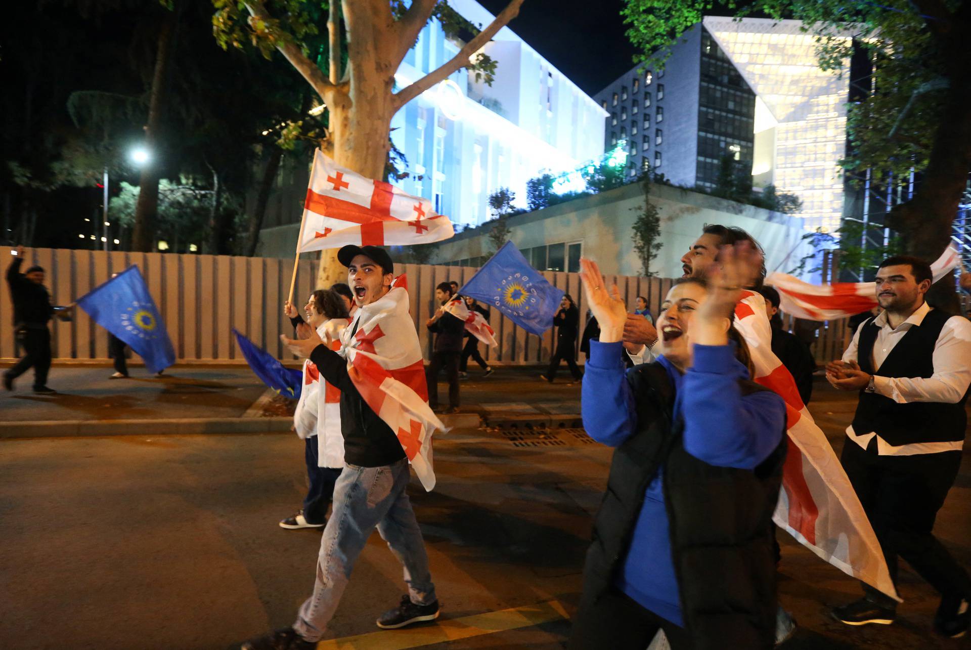 Supporters of the Georgian Dream party celebrate after the announcement of exit poll results in Tbilisi