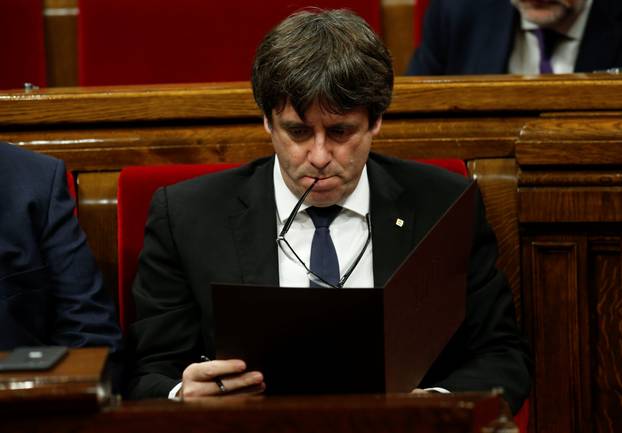 Catalan President Carles Puigdemont reviews his notes at the start of a plenary session at the Catalonian regional parliament in Barcelona