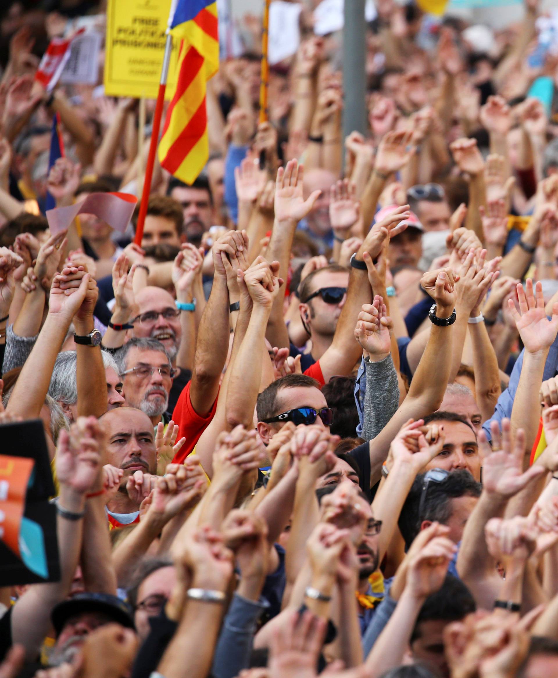 People raise their hands during a demonstration organised by Catalan pro-independence movements ANC (Catalan National Assembly) and Omnium Cutural, following the imprisonment of their two leaders in Barcelona