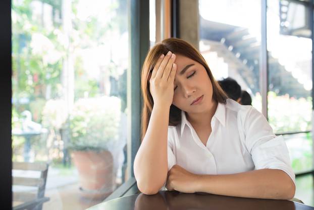 Woman has head ache at coffee shop