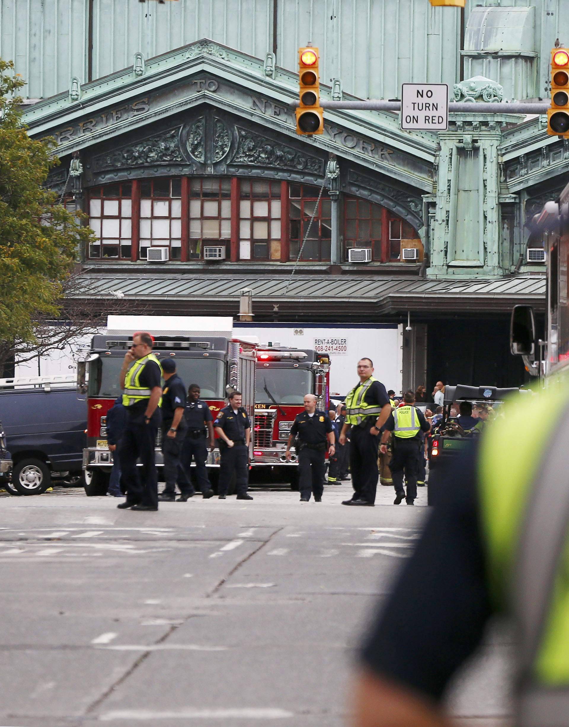 Hoboken police officers look over the scene of a train crash where a New Jersey Transit train derailed and crashed through the station, injuring more than 100 people, in Hoboken