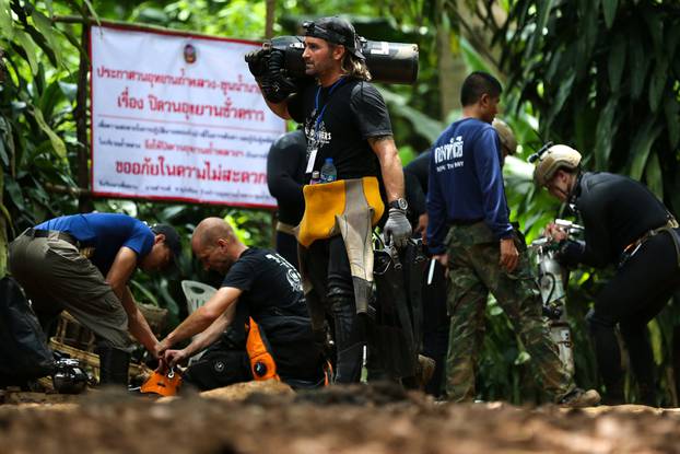 International divers carry equipments as they prepare to go in to Tham Luang cave complex, as members of an under-16 soccer team and their coach have been found alive according to local media in the northern province of Chiang Rai