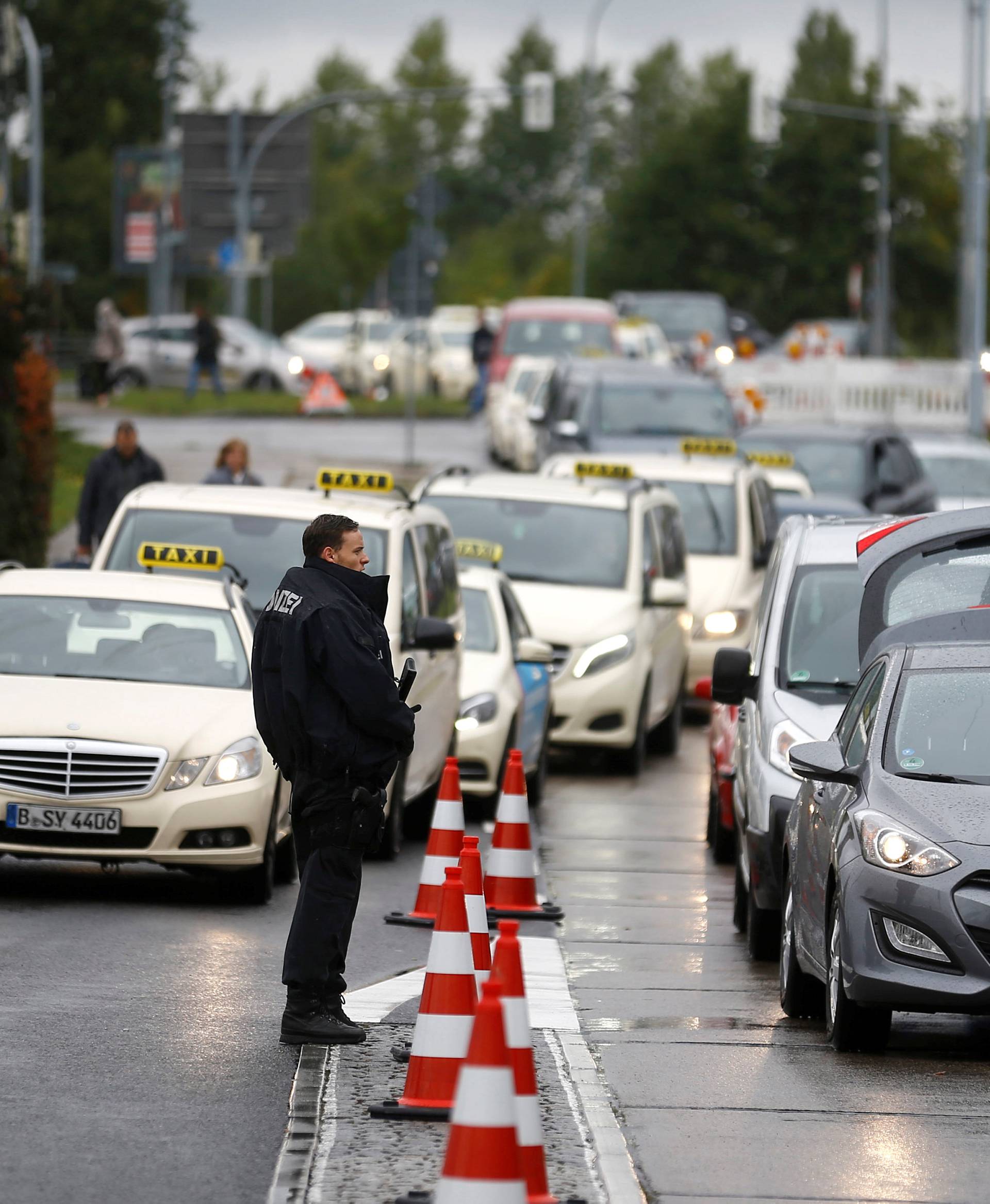 German policemen check cars on the entrance to Berlin-Schoenefeld airport, in Schoenefeld