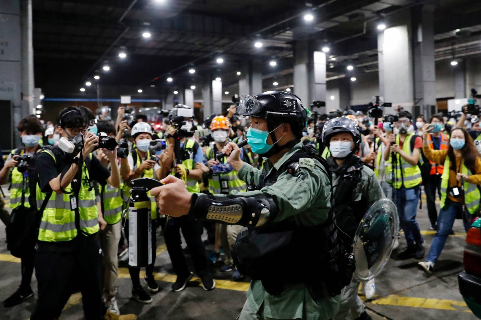FILE PHOTO: File photo of a riot police officer holding a pepper spray as he tries to disperse anti-government protesters after a vigil to mourn student’s death, in Hong Kong