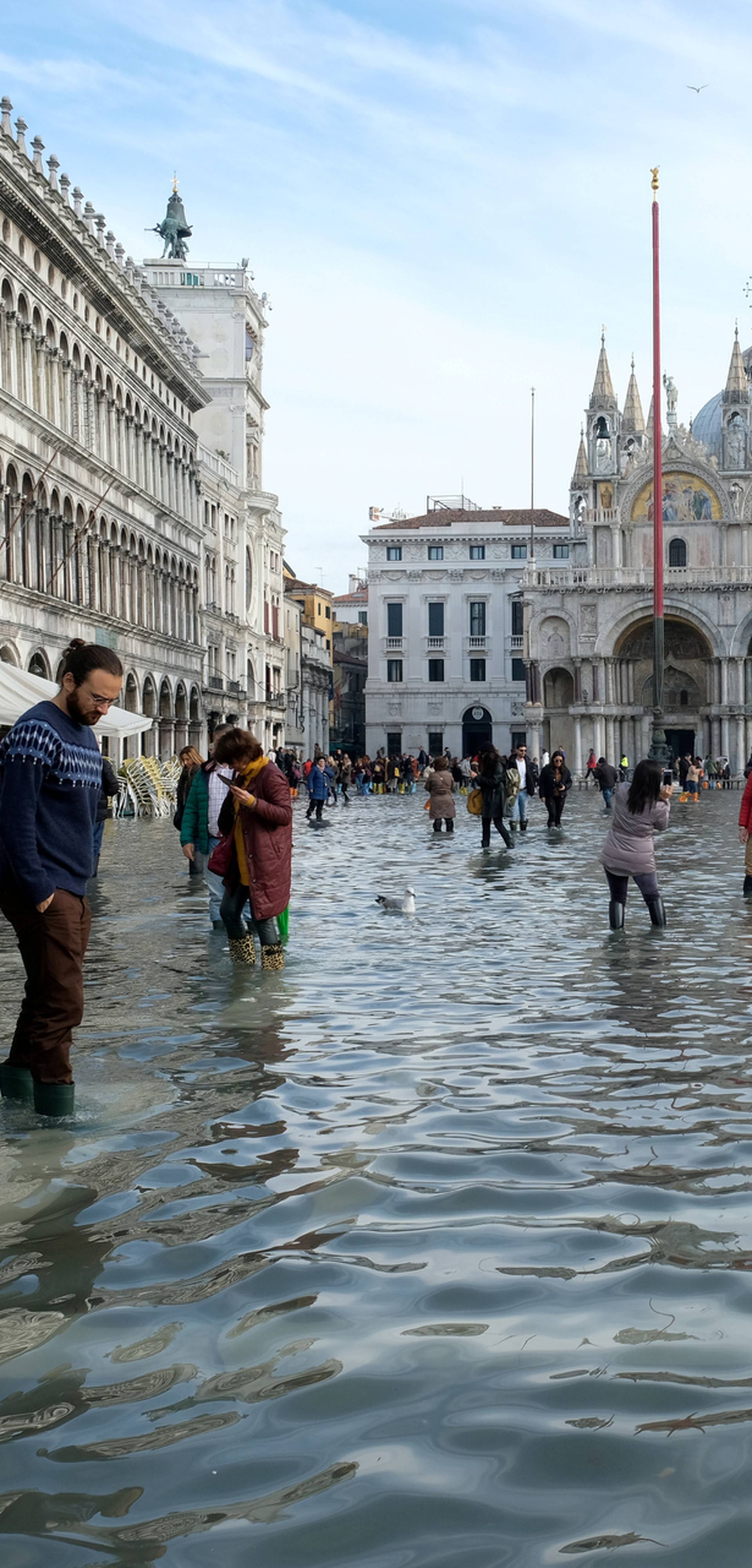 FILE PHOTO: Tourists walk in St. Mark’s Square after days of severe flooding in Venice