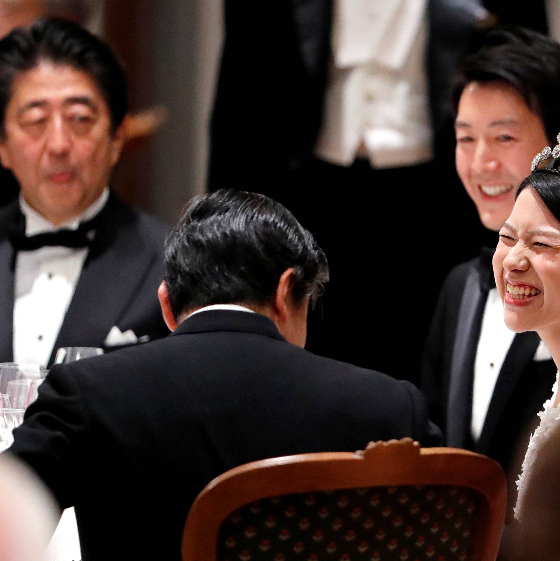 Japan's former princess Ayako Moriya and her husband Kei Moriya talk with Crown Prince Naruhito as Prime Minister Shinzo Abe looks on at their wedding banquet in Tokyo