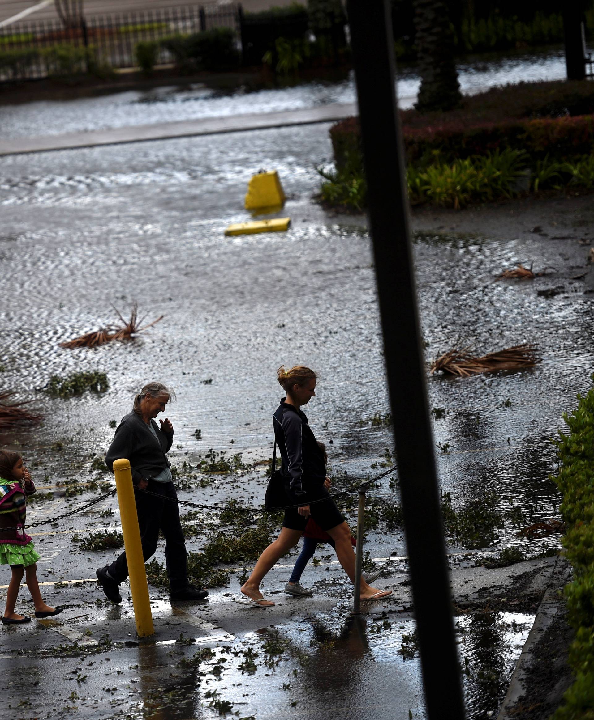 A family walks through floodwaters after Hurricane Irma