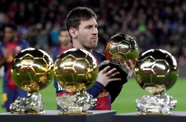 FILE PHOTO: Barcelona's Messi poses with his four Ballon d'Or trophies in Barcelona