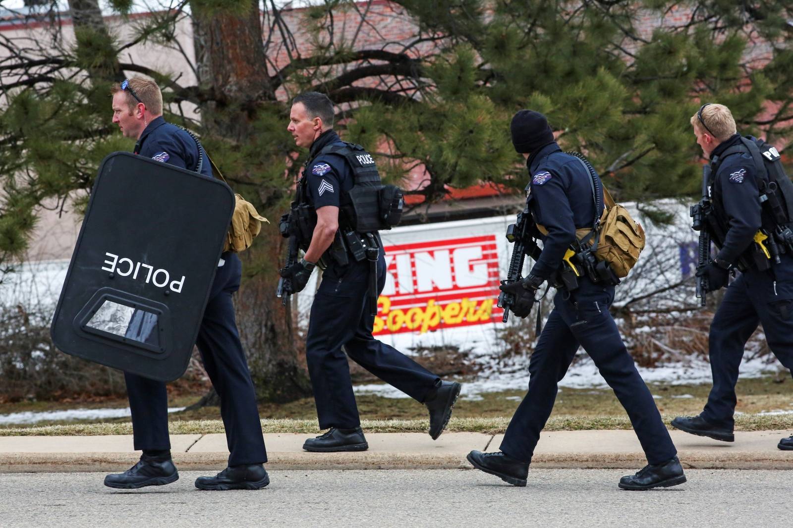 Law enforcement officers stand at the perimeter of a shooting site at King Soopers grocery store in Boulder