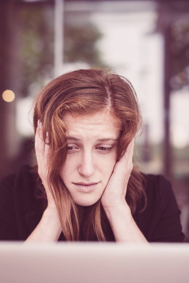 Desperate Young Woman Looking at Laptop Screen