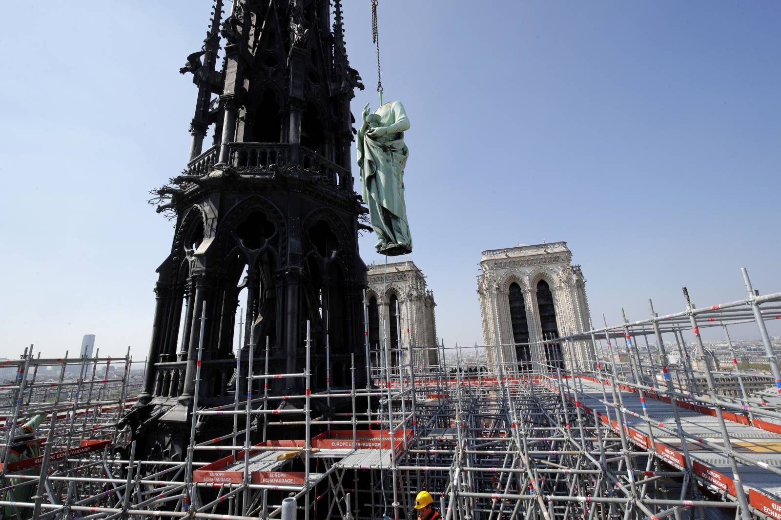 FILE PHOTO: A statue of Saint John is removed from the spire of Notre Dame cathedral by a crane before restoration work, in Paris