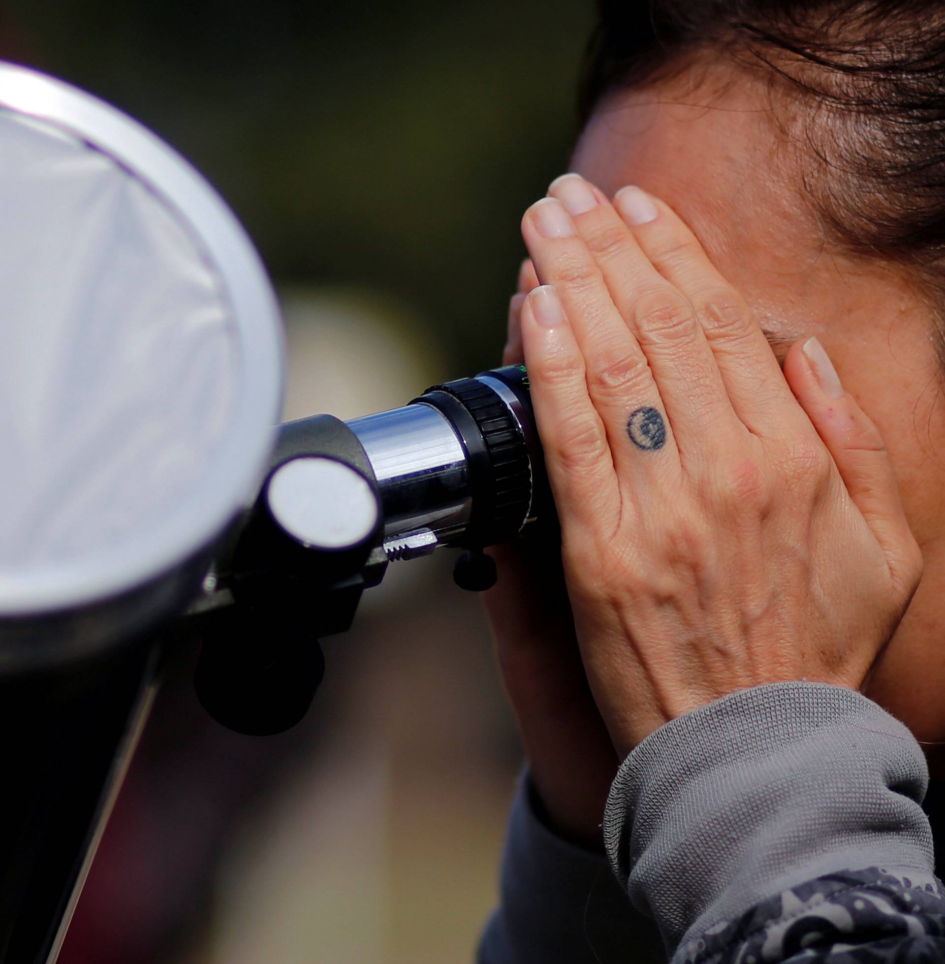 A woman uses a telescope to observe the planet Mercury transit in front of the sun outside Buenos Aires' planetarium