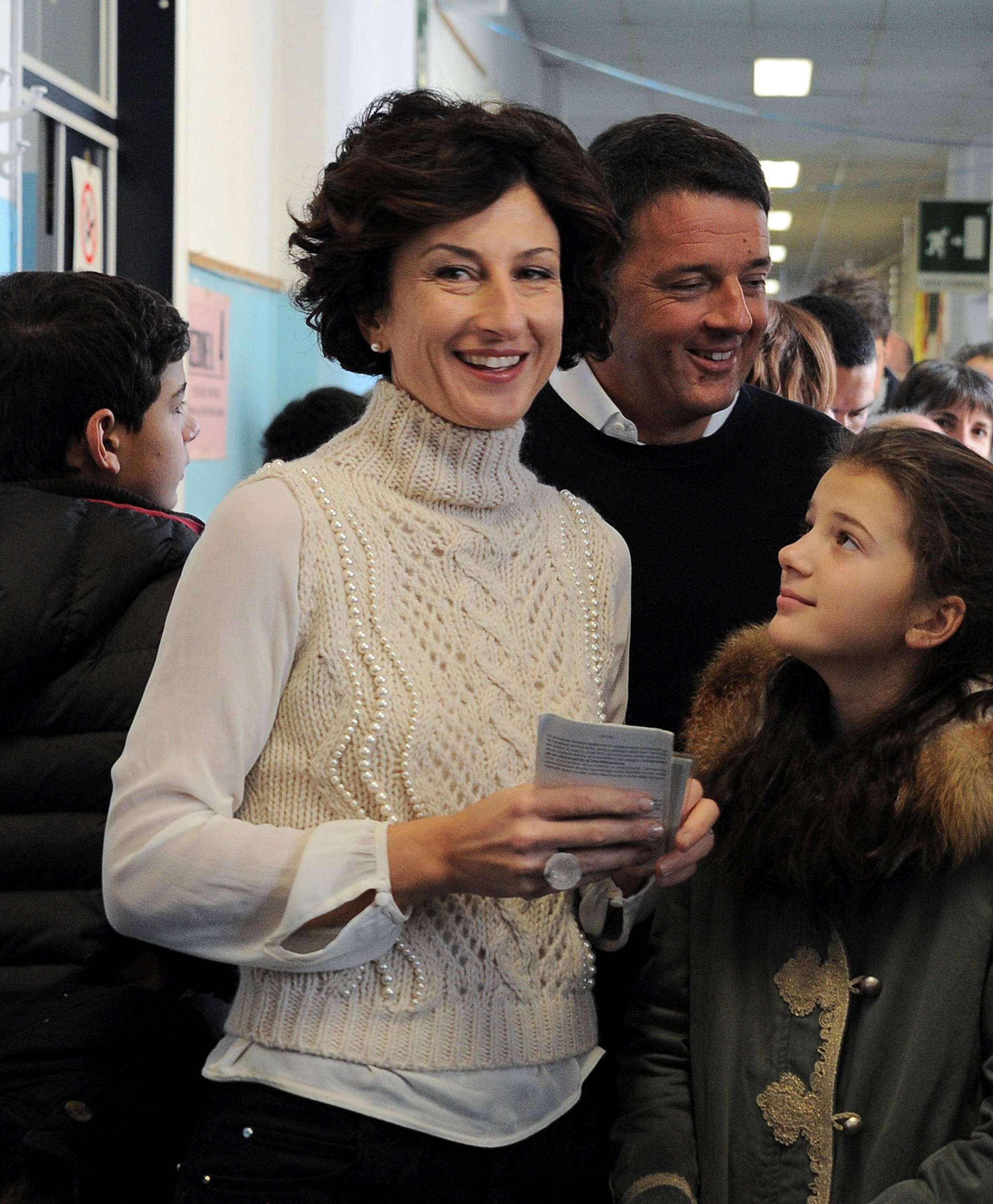 Italian Prime Minister Matteo Renzi and his wife Agnese smile as they wait to cast their votes with they children during the referendum on constitutional reform, in Pontassieve