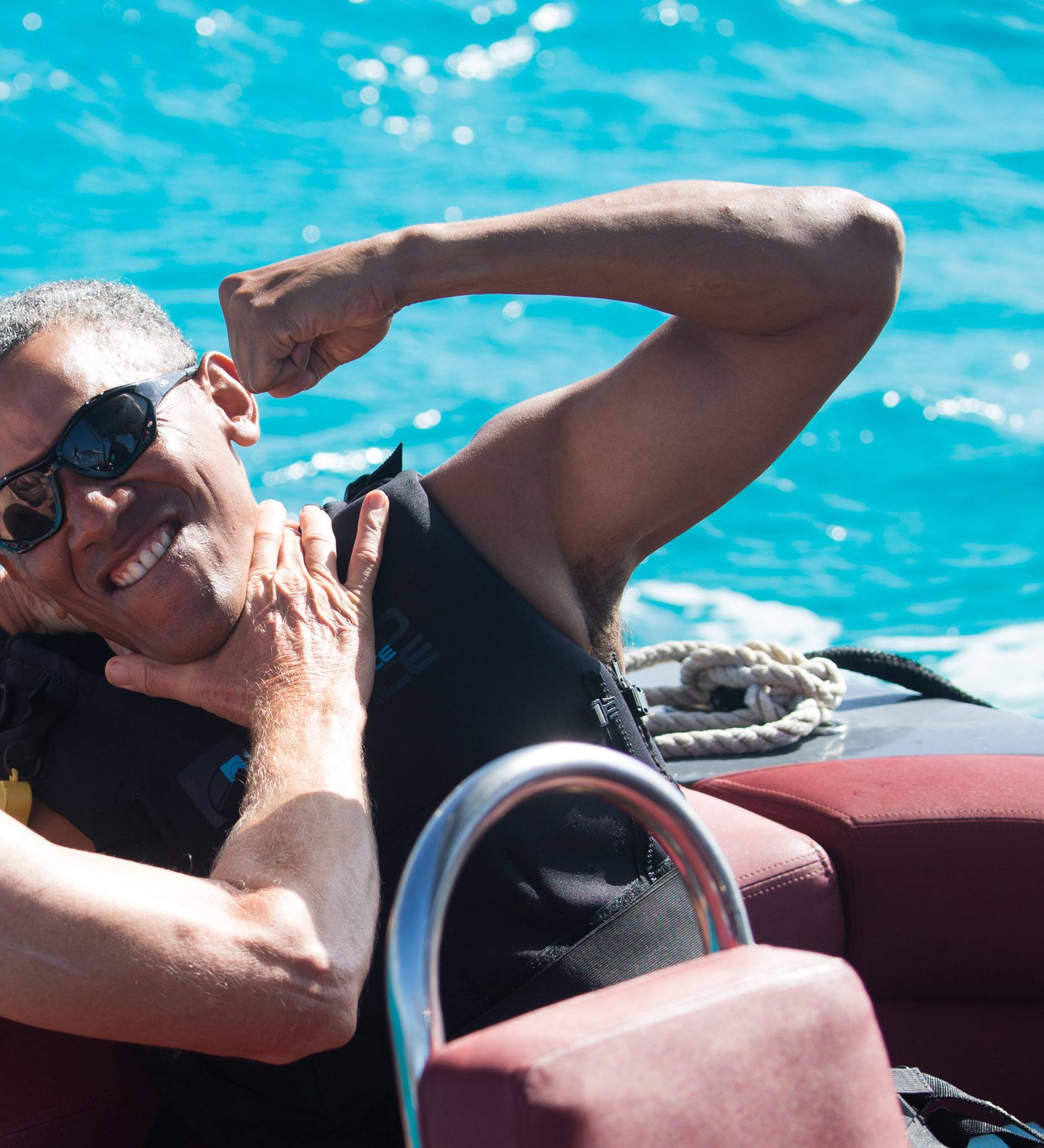 Former U.S. President Barack Obama and British businessman Richard Branson sit on a boat during Obama's holiday on Branson's Moskito island, in the British Virgin Islands, in a picture handed out by Virgin