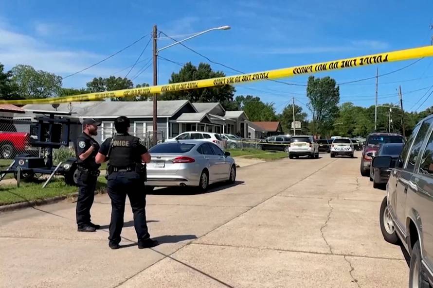 Police officers secure the scene where eight children, with ages ranging from 1 to 14, were killed in a mass shooting in Shreveport