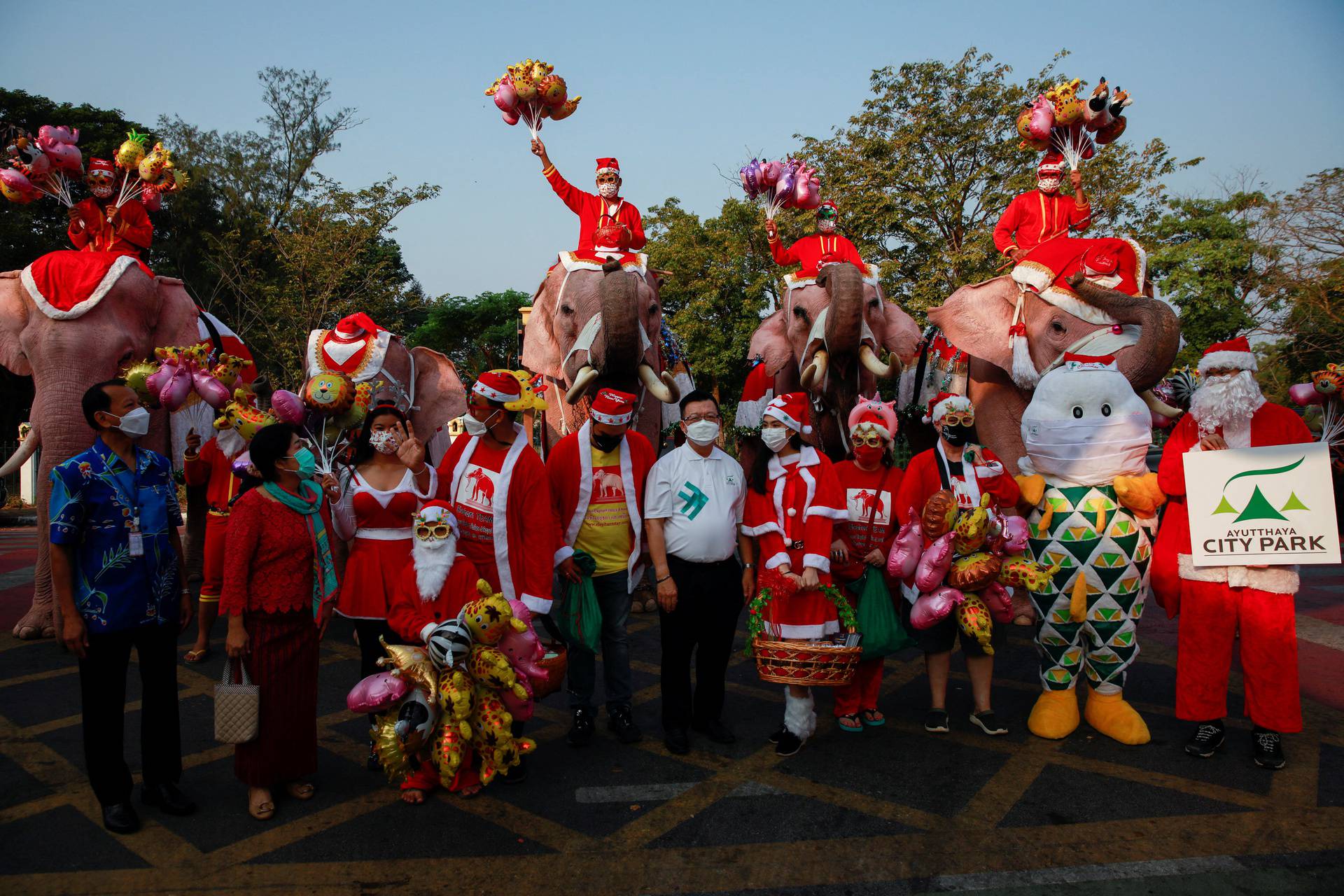 Elephants in Santa Claus costumes vist to a school