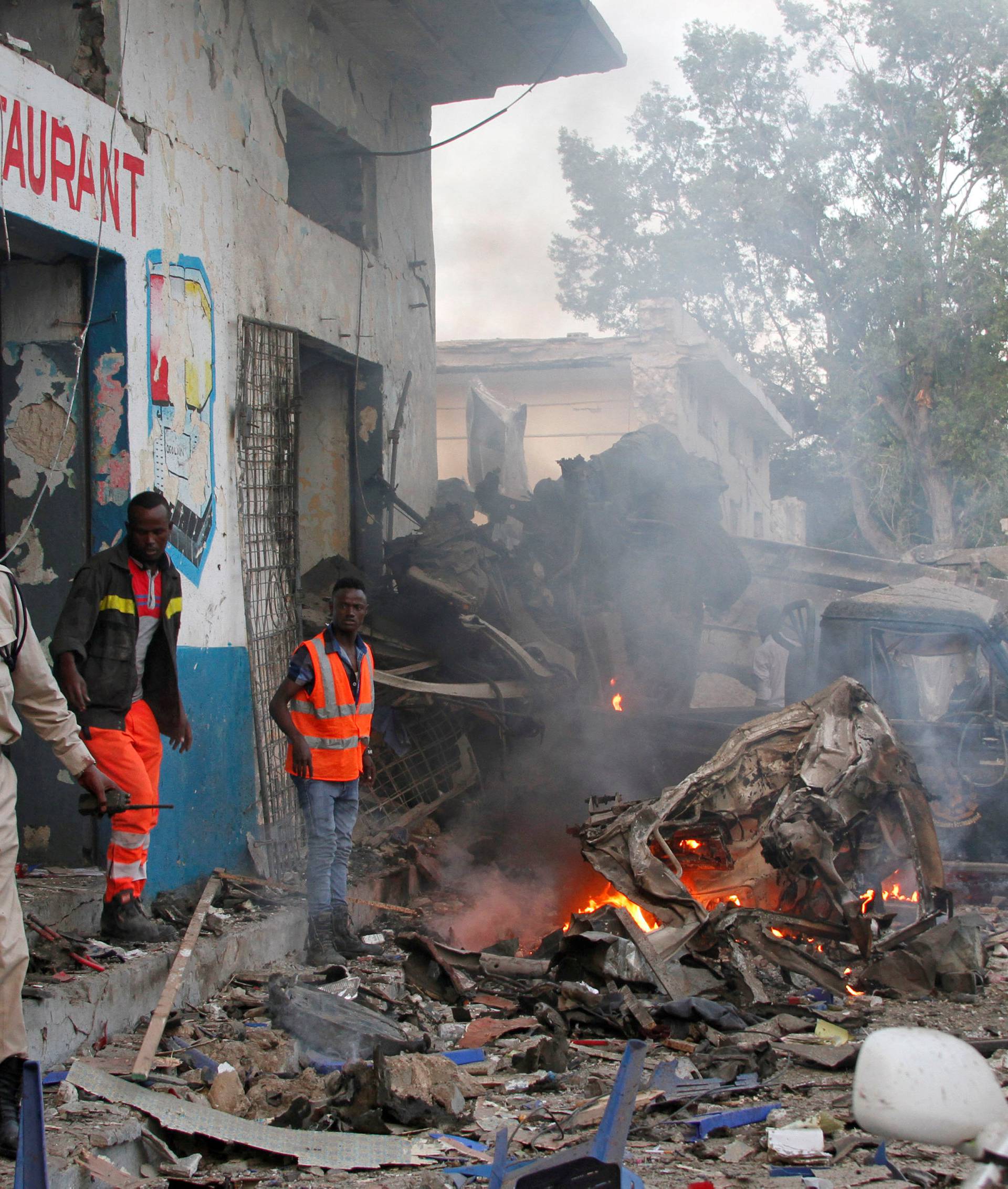 Somali security officers secure the scene of a suicide car bomb explosion, at the gate of Naso Hablod Two Hotel in Mogadishu